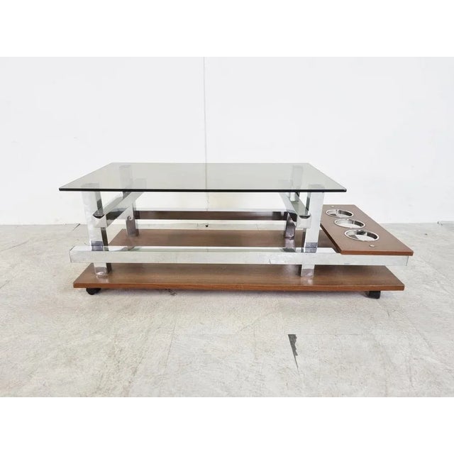 Mid-century coffee table made from teak and chrome base with a smoked glass top. It has an attractive geometrical design...