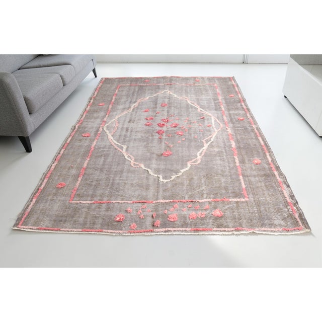 This is a vintage Turkish Oushak rug from the Mid 20th Century. The piece was hand-knotted.