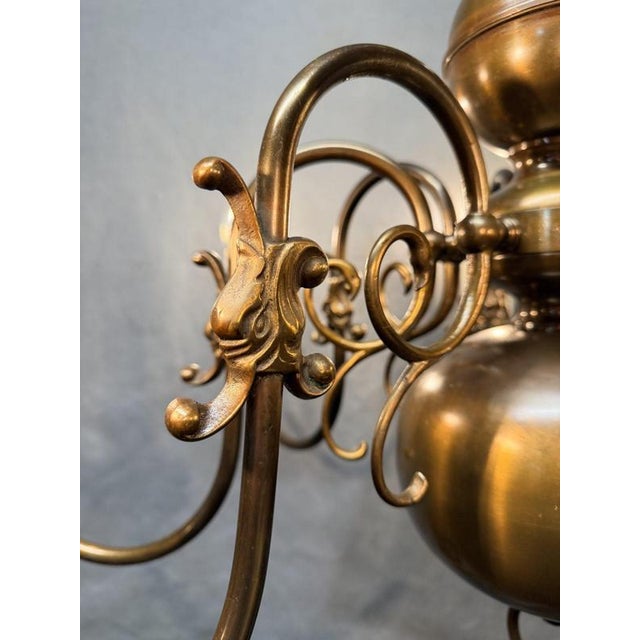 A very good antique Flemish chandelier in brass, with eight sweeping branches radiating from a central baluster column....