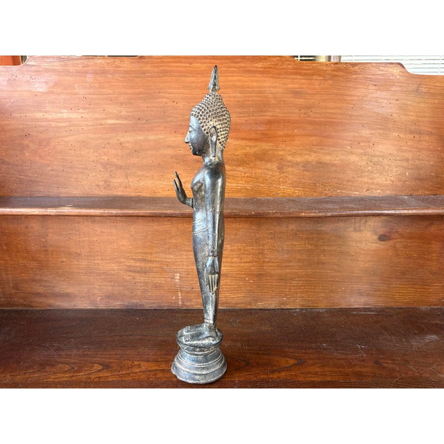 Elegant standing Buddha in solid bronze, originating from Burma (Myanmar), crafted in the traditional Mandalay style in...