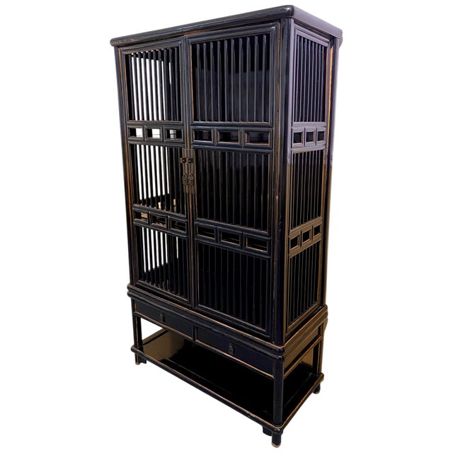 An early 20th century Chinese Black Lacquered Lattice Cabinet, in the Ming Dynasty style. The cabinet is in two parts, a...