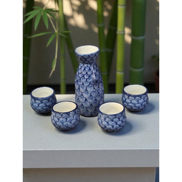 This vintage Chinese blue and white sake set includes a decanter and four cups, showcasing traditional Chinese design and...
