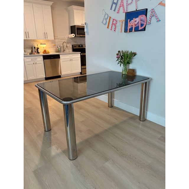 Smoked glass, stainless steel dining table designed by Italian designer Gianfranco Frattini in the '70s, reproduced by CB2...