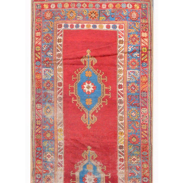 An amazing early 20th century Turkish Konya runner with three large indigo diamond medallions abasing a bold crimson...