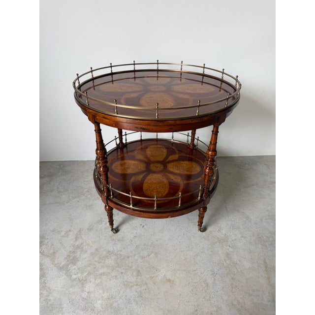 A beautifully crafted vintage Theodore Alexander two-tier accent table featuring elegant Regency styling. This round table...