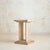 An Italian pedestal from the 1970s, sculpted from creamy travertine with visible pits, mineral inclusions, and subtle...