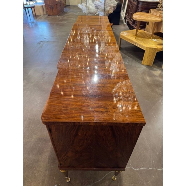 This Mid Century French Inlaid Sideboard with Brass Details is a stylish and elegant piece of furniture that embodies the...