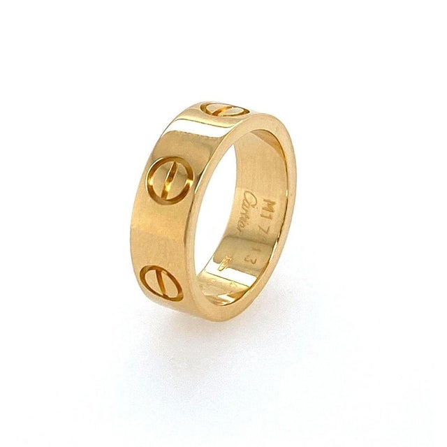 This authentic Cartier Love band ring is crafted in solid 18k yellow gold and features the iconic screw motif design that...