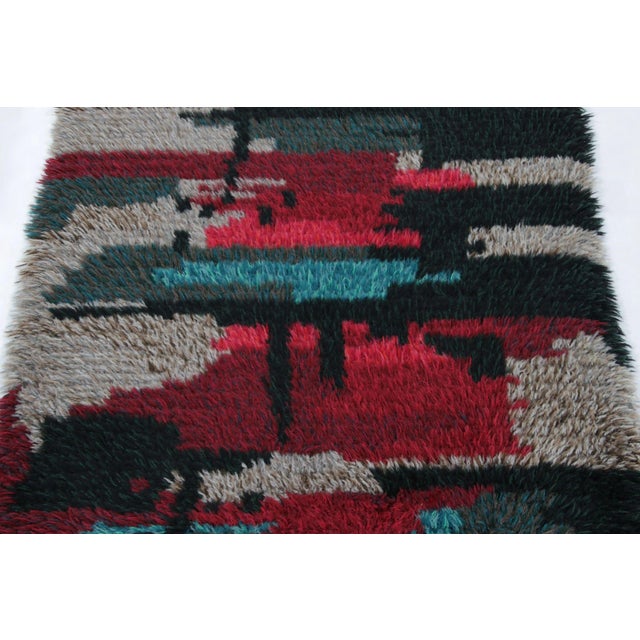 Hand-knotted in lush, high-pile wool in Sweden circa 1960-1970, this 3x5 vintage Swedish Rya rug is a bold new addition to...