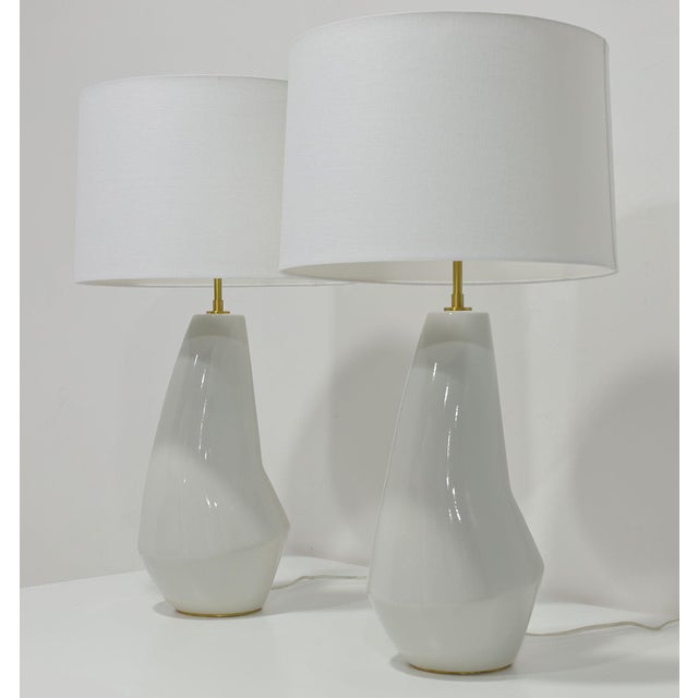 Illuminate your space with the Pair of Contour Artic White Ceramic Table Lamps designed by Kelly Wearstler, a masterpiece...
