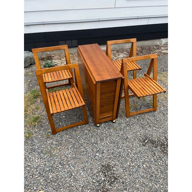 A practical and stylish dining table that contains four folding chairs. Designed in the mid 60s. Both stylish and highly...