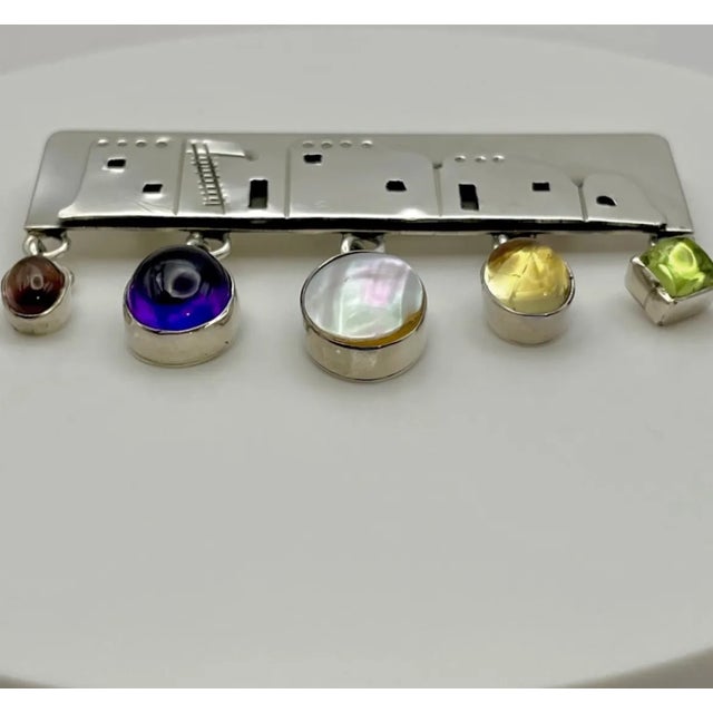 Vintage sterling silver with dangling gemstones brooch done in overlay technique in which a design is cut out of one...