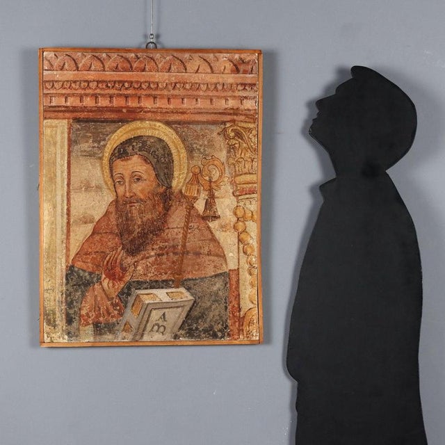 Fake fresco tear. Emulating an ancient fresco, the face of Saint Anthony the Abbot is depicted here, recognizable by...