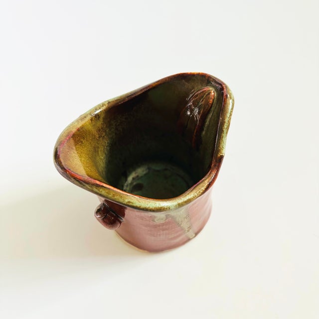 A vintage hand made studio pottery cup. Green and reddish brown drip glaze. Signed on the base. Measures 3.75"W x 3"D x...