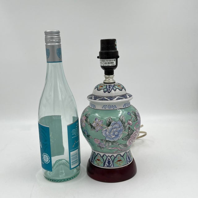 Charming petite vintage ceramic table lamp featuring a pastel floral Chinoiserie design. The lamp has a ginger jar style...