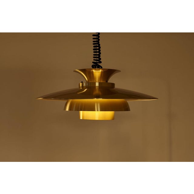 Featuring a sculptural, tiered design. Based on a reflective lighting system, it directs light downward and outward while...