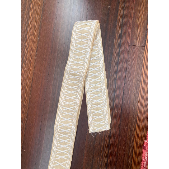 The Schumacher Tikki Tape is a substantial trim with a graphic crisscross pattern embroidered in raffia. Beachy and boho-...