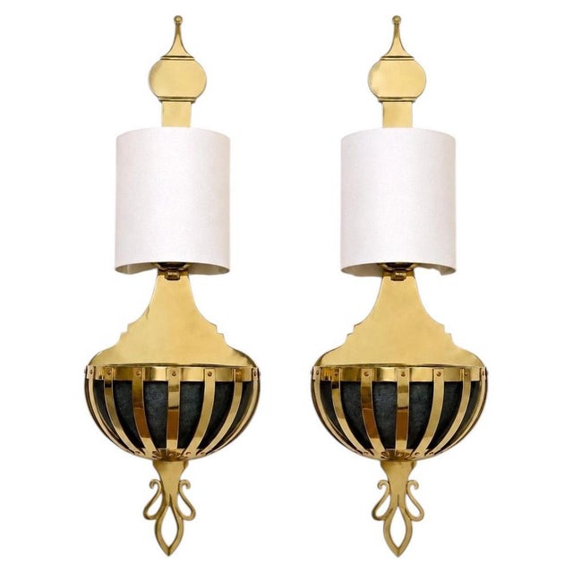 An exceptional pair of Spanish Hollywood Regency wall sconces by Valenti, crafted in richly finished brass with integrated...