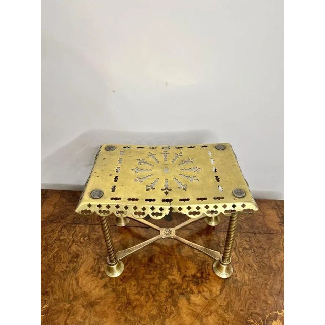 Quality antique Edwardian large brass trivet having a quality antique Edwardian large brass trivet raised on four twist...