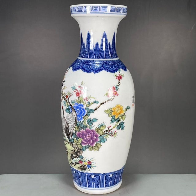 A beautiful pair of Chinese porcelain vases. The white ground is decorated with vibrant Famille Rose enamels, featuring...