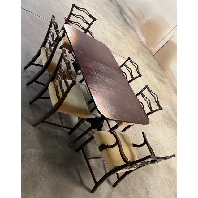 Elegant vintage dining set featuring a rich mahogany-finished dining table paired with six sculptural dining chairs. The...