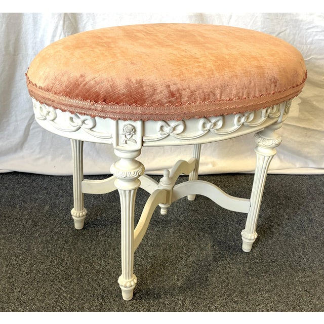 Precious vintage French style vanity stool. It's made of wood with carved bow details on the apron, fluted legs, and...