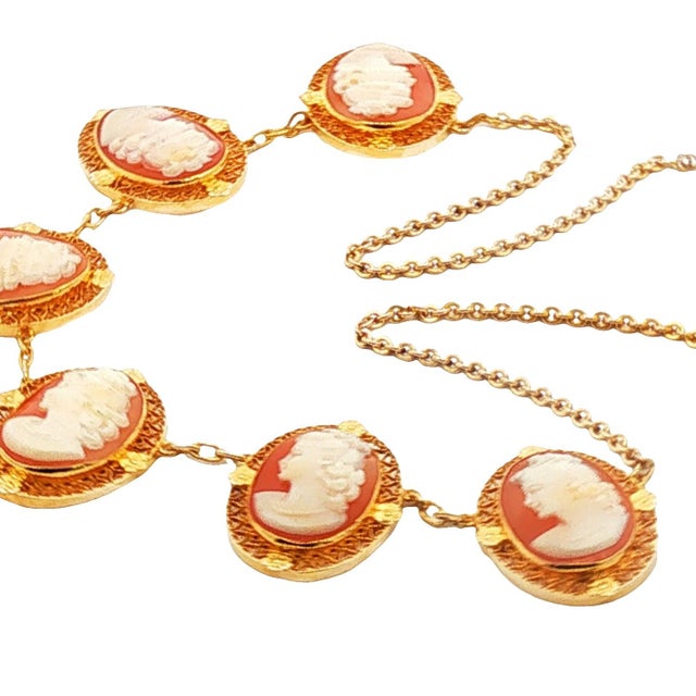 A Mid-Century cameo necklace. This necklace features intricately carved cameos, each depicting a classical profile. The...