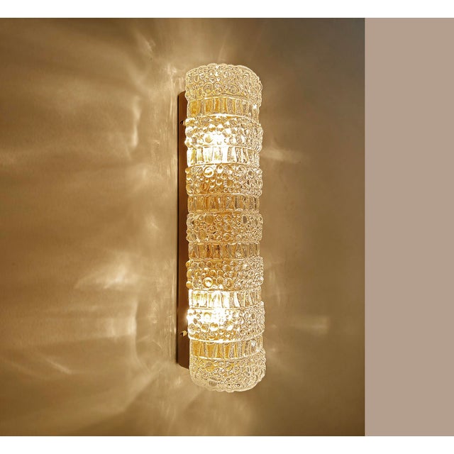 Pair of vintage sconces featuring a glass shade with an alternate relief of corrugated columns and bubble patterns mounted...