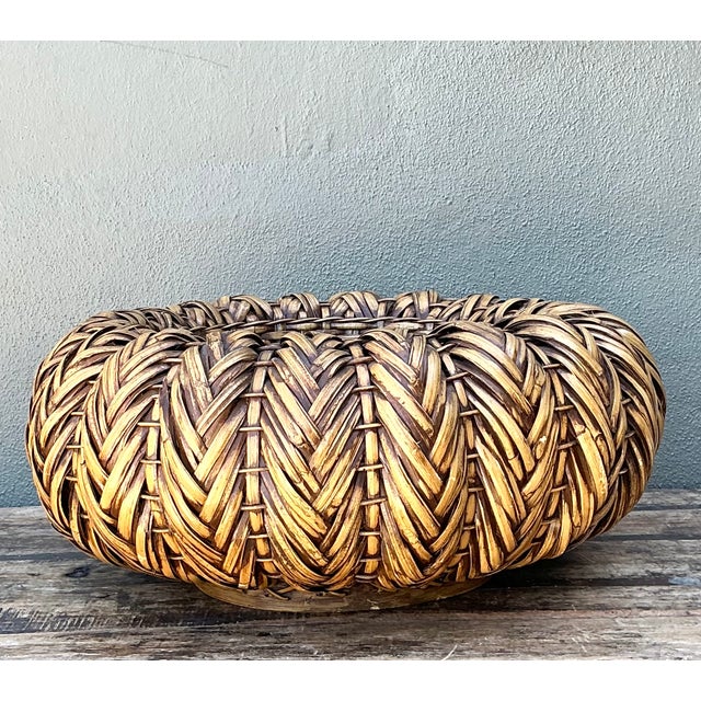 This vintage handcrafted rattan centerpiece is a generously scaled woven basket that brings natural texture and relaxed...