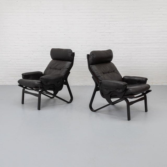 1970s lounge chair with a flowing bentwood frame running in one continuous line from front to back. design reflects...