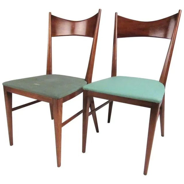 This stylish pair of Paul McCobb dining chairs feature's sculpted frames with contoured seat backs and tapered legs. Rich...