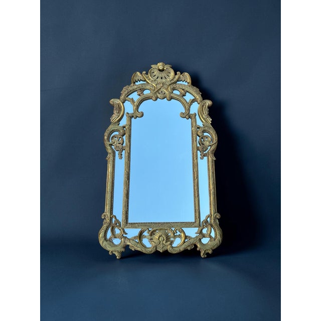 A very elegant Regency-style mirror with carved and gilded wooden side panels, likely dating from the 1930s. Its rich...