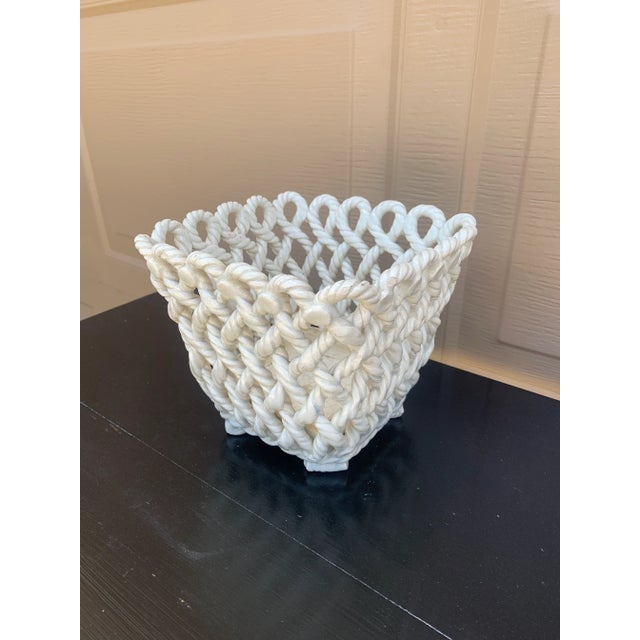 An elegant trompe l'oeil porcelain cachepot crafted in the form of a handwoven rope basket. Executed in glossy white...