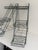 Pair of matching three-tier wrought iron plant stands with openwork scroll design. Each stand has three basket-style...