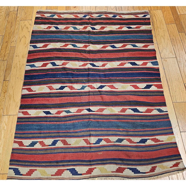 Handwoven in the Caucasus region in the first quarter of the 20th century, this vintage kilim embodies the authentic...