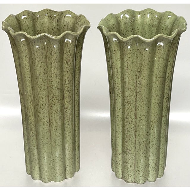 A pair of stylish mid-century hand made pottery vases, having speckled asparagus green glaze that entirely covers both the...