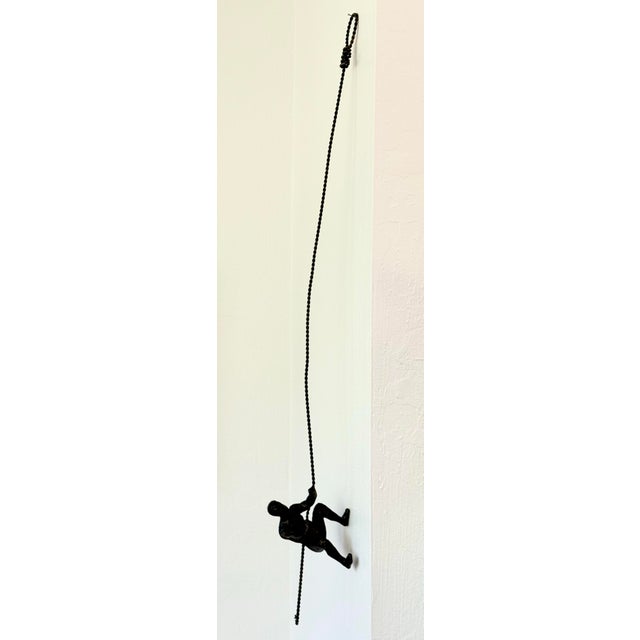 A wonderful cast metal sculpture of a man climbing. What is he climbing? A mountain? A wall? The governor’s mansion? You...