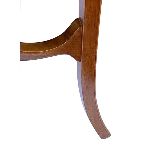 the well-figured round top with an inlaid laurel-leaf and interlaced ribbon perimeter border; above a plain frieze apron...