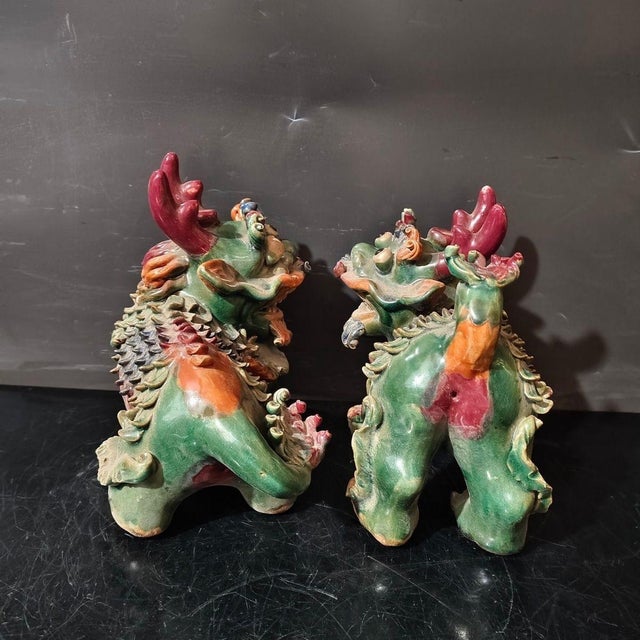 Add a bold and auspicious statement to your space with this striking pair of vintage Shiwan Kiln glazed ceramic mythical...
