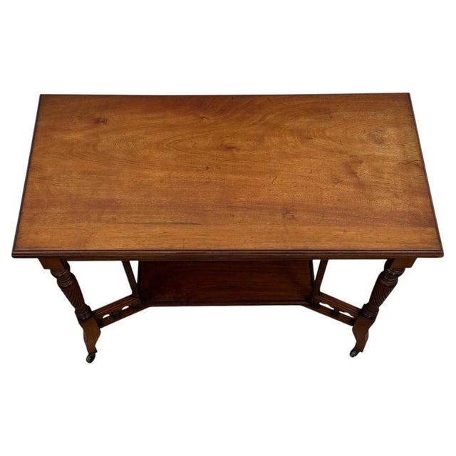 A beautifully proportioned early 20th-century English Edwardian side table, finely constructed in walnut and displaying...