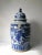 This blue and white porcelain jar is adorned with hand painted flying phoenix. The lid has a small foo dog on top. There...
