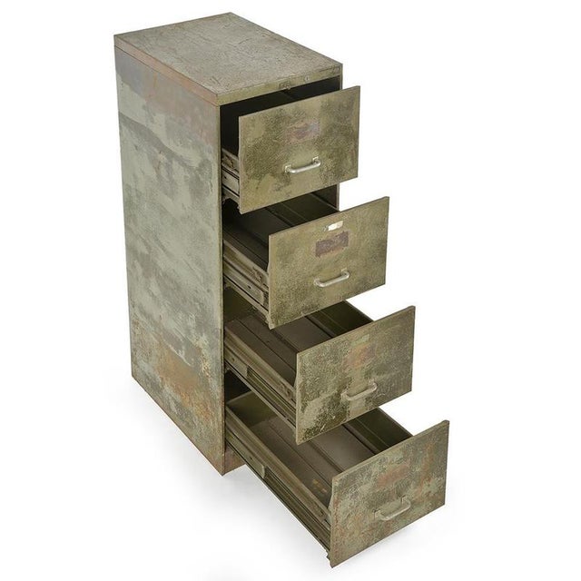 Originating from the administrative and industrial world of the 20th century, this antique filing cabinet in patinated...