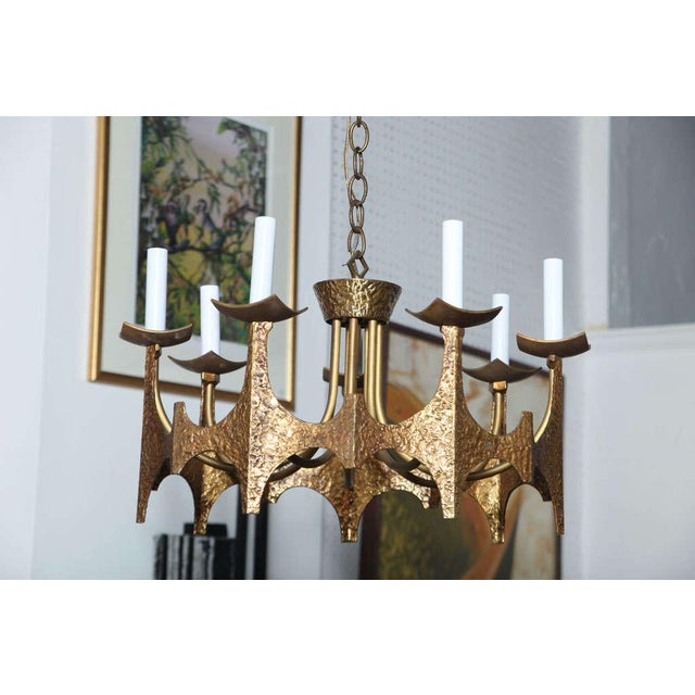 This Medieval touch, brutalist hammered mid-century modern 7-arms chandelier, was made by Moe Bridges circa 1970s. The...