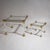 Two coffee tables of square form with faceted column legs featuring stylized brass capitals and bases. The tabletops are...