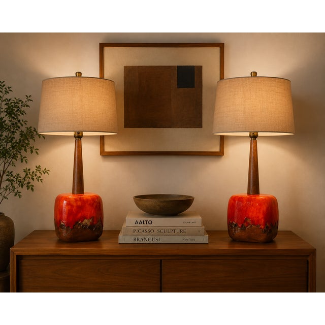 A striking pair of mid-century modern ceramic table lamps attributed to Poole Pottery, featuring richly expressive lava...