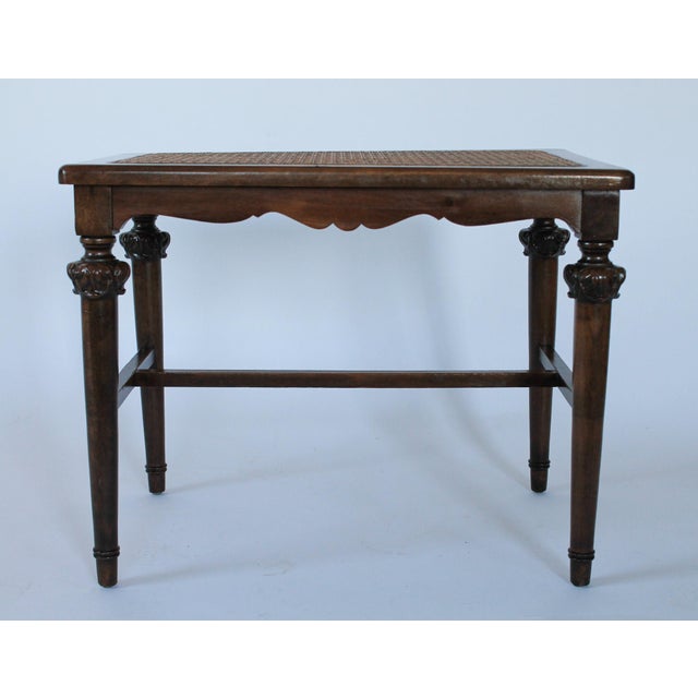 Antique oak wood bench with caned seat, tapered legs and carved wood details. No makers mark. Some light age wear to wood....
