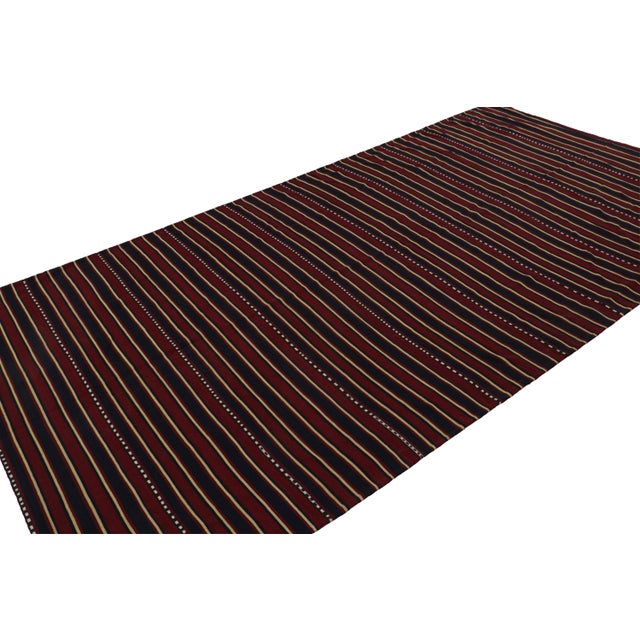 Handwoven in wool, circa 1950-1960, this 5'11''x5'7'' vintage Afghan tribal kilim rug, with horizontal stripes, features...