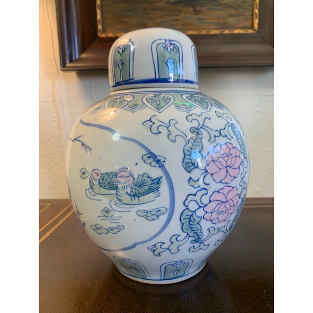 Beautiful vintage Asian porcelain ginger jar featuring delicate blue and soft pastel hand-decorated floral, bird, and...