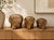 Charming graduated set of three vintage ceramic elephant sculptures with a warm beige and brown marbled finish. Each...