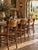 A striking set of four antique Crocker dining chairs, distinguished by their graceful curved lines, warm aged wood, and...